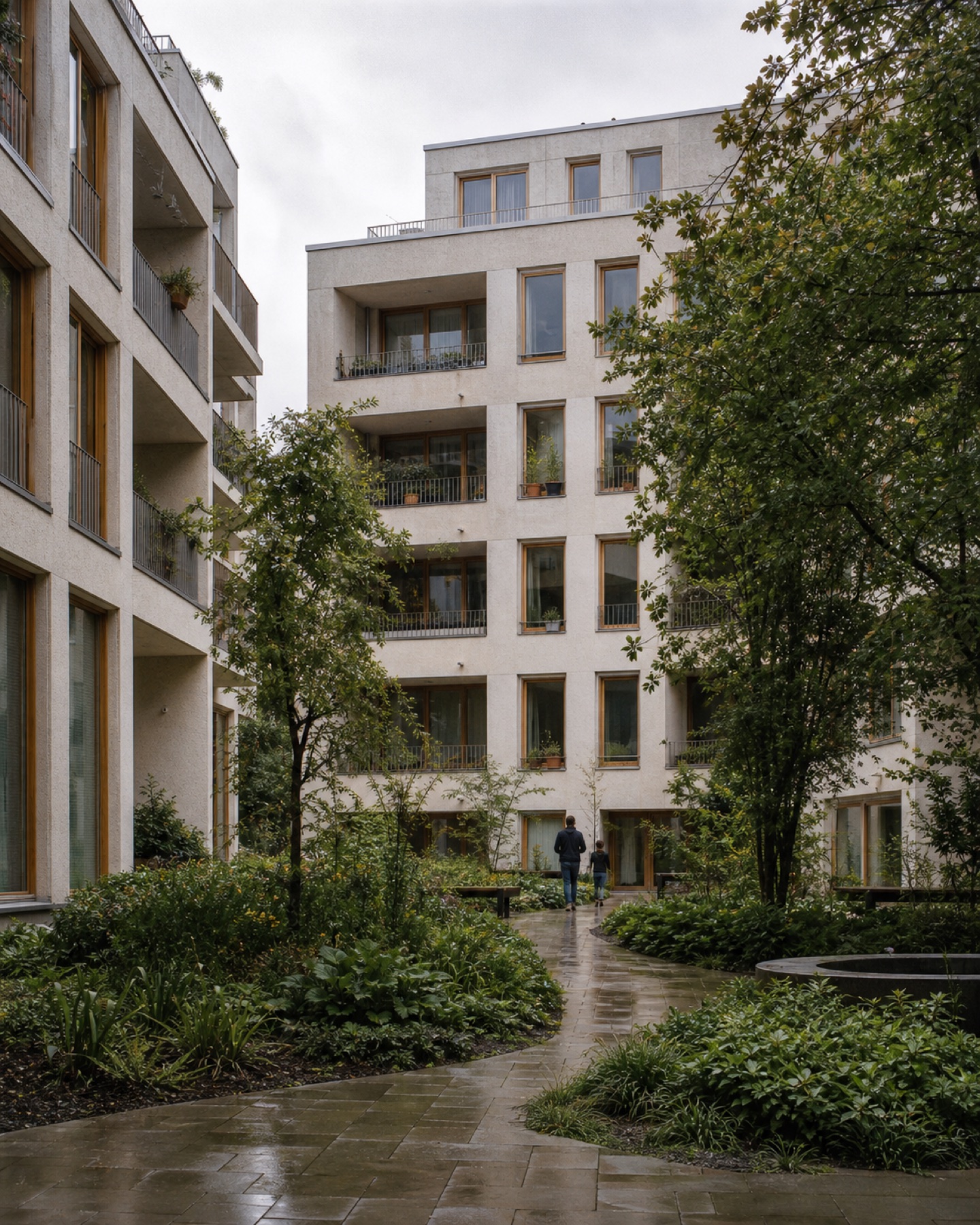 Begrünter Wohnhof mit hellen Fassaden und Holzelementen
